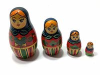 Front view showing the detailed painted faces and traditional dress on the four nesting dolls arranged by size.