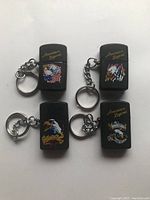 Photo showing all four American Legend vintage mini key chain lighters, each with patriotic eagle and flag designs, attached to key rings.