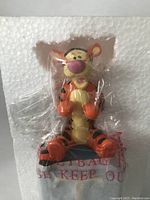 Tigger figurine sealed in clear plastic, mounted on block inside original box with visible protective foam.
