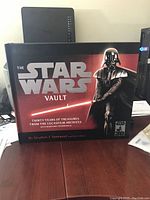 Front cover of The Star Wars Vault book showing the title, Darth Vader image, and design elements.
