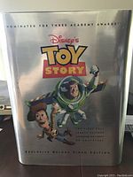 Front view of the metallic silver case featuring Woody and Buzz Lightyear, labeled as Toy Story Exclusive Deluxe Video Edition with Academy Award nominations.