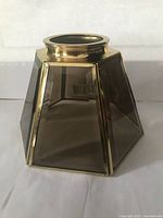 Hexagonal solid brass light shade with six beveled smoked glass panels shown from side angle