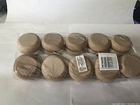 Pack of 10 unpainted wooden yo-yos in a clear plastic bag, showing smooth round shape and light wood tone.