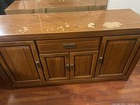 Front view of wooden cabinet/table showing top surface wear, drawer, and doors closed