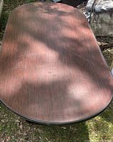 Top view of large rectangular conference room table with a wood finish and rounded corners.