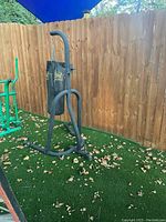 Photo of Everlast heavy punching bag hanging from black metal stand with foam padding outdoors.