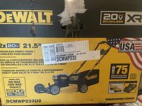 Front of box showing DeWALT branding, 2×20V 21.5'' specs and model number DCMWP233U2