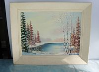 Framed oil painting showing the full artwork and frame, winter landscape with birch and fir trees by a river.