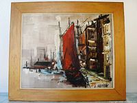 Frontal view of the framed oil painting showing the abstract harbor scene with red sailboat and buildings.