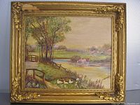 Full view of the framed oil painting depicting a farm landscape with trees, a pond, cows, and ducks.