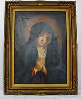 Front view of the oil painting depicting the Virgin Mary in a dark hooded cloak and golden frame.