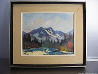Framed oil painting showing Canadian mountain landscape and river with visible signature and overall artwork.