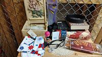 Photo showing mixed lot items including jewelry box, patterned fabric, insoles, sunglasses, cosmetic bottles, boxed belt, and tissues.