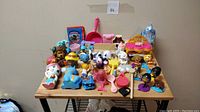 Overview of assorted small toys including animal and character figures, and small accessories on table
