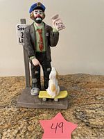 Front view of vintage Emmett Kelly porcelain clown policeman figurine holding ticket with cat on skateboard and speed limit sign.