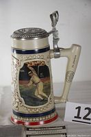 Side view of the stein showing Joe Jackson pitching artwork, pewter lid, and baseball bat handle design.
