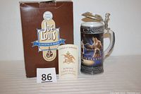 Joe Louis Budweiser stein with box and certificate of authenticity in photo, showing front of box and stein with lid open.