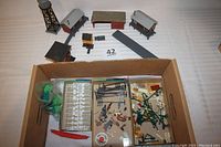 Full view of all HO scale model train buildings along with railroad signs, light posts, telephone poles, and foliage arranged neatly on a white background.