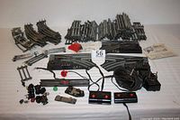 Full laid out lot photo showing all track pieces, switches, uncoupler controller, and bumper with wires and controllers visible.