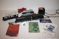 Overview of train set with locomotive, tender, various cars, instruction manuals, and transformer on display.