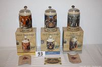 Three Budweiser Endangered Species Series steins on their boxes with collector cards visible, showing Asian Tiger, Gray Wolf, and African Elephant designs.