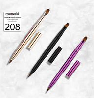 Three retractable dual-end makeup brushes laid out on white background in gold, black, and purple metallic handles with caps removed from one end of each brush.