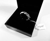 Ring displayed in a black jewelry box with attached price tag.