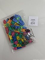 Clear plastic bag containing 10 assorted mini push pop bubble keychains with metal ball chain keyrings, visible colors include blue, pink, green, orange, and multicolor.