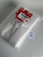 Clear sealed plastic package containing a single white Miele vacuum bag with red plastic collar and clips for attachment.