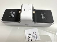 Top view of the Powerextra dual charger dock showing two controller slots with controller icons on black surfaces and a white central section.