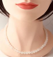 Necklace displayed on mannequin to show length and appearance.