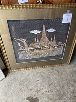 Full view of the framed silkscreen artwork showing the ornate boat and temple scene in a gold frame with matting.