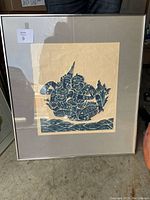 Framed artwork showing two blue figures reclining, with faded grey matting and silver frame.