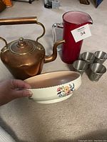 Photo showing all items: copper kettle, red glass pitcher, hand-painted floral bowl, and four pewter small glasses.
