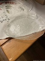 Fish-shaped glass serving plate showing detailed textured scales and fins