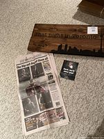 Photo showing the wooden wall hanging, The Hip-Standard special edition newspaper, and Gord Downie memorial card.