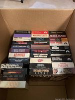 Photo of 31 VHS movie tapes showing titles such as Ace Ventura, The Hitchhiker's Guide to the Galaxy, The Babe, 2001 A Space Odyssey, Star Trek Generations, and more arranged in a box