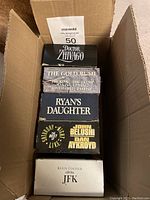 Box containing 5 double cassette VHS movies: Doctor Zhivago, The Gold Rush, Ryan's Daughter, The Best of SNL, JFK