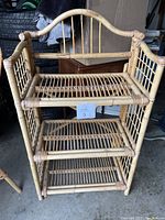 Photo showing front view of the 3-tier wicker shelf in garage environment with other items in background