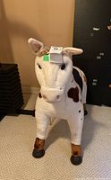 Child's horse riding toy with white and brown spotted plush body, brown vinyl hooves and ears. Heavy and sized about 30x36 inches. Vinyl material shows peeling and needs cleaning.
