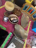 Photo showing silver Arthur Price clock, ceramic leaf dishes, glass candle holder, and foot massage stone on table.