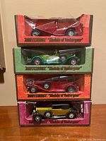 Front view of four Matchbox Models of Yesteryear die-cast cars stacked vertically in original packaging, showing colors and box designs.