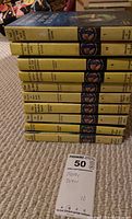 Stacked view of all 10 Nancy Drew books showing yellow spines and titles.