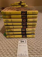 Stack of 8 Nancy Drew books showing the spines with the iconic yellow coloring and rank numbers on spine.