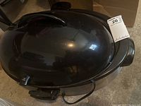 Closed black Rival oval roaster oven showing the lid and power cord.
