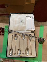 Fitted case open showing six spoons and one candle snuffer laid out