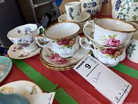 Photo showing four Royal Albert china teacups and saucers with visible floral patterns and gold trim.