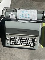 Top view showing the full typewriter, keyboard, and 'FOR SALE' sign.