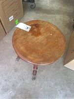 Top angled view showing round wooden seat with scratches and discoloration.