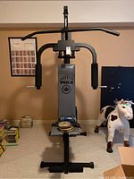 Complete front view of York home gym showing padded arms, backrest, and weight plates on seat.